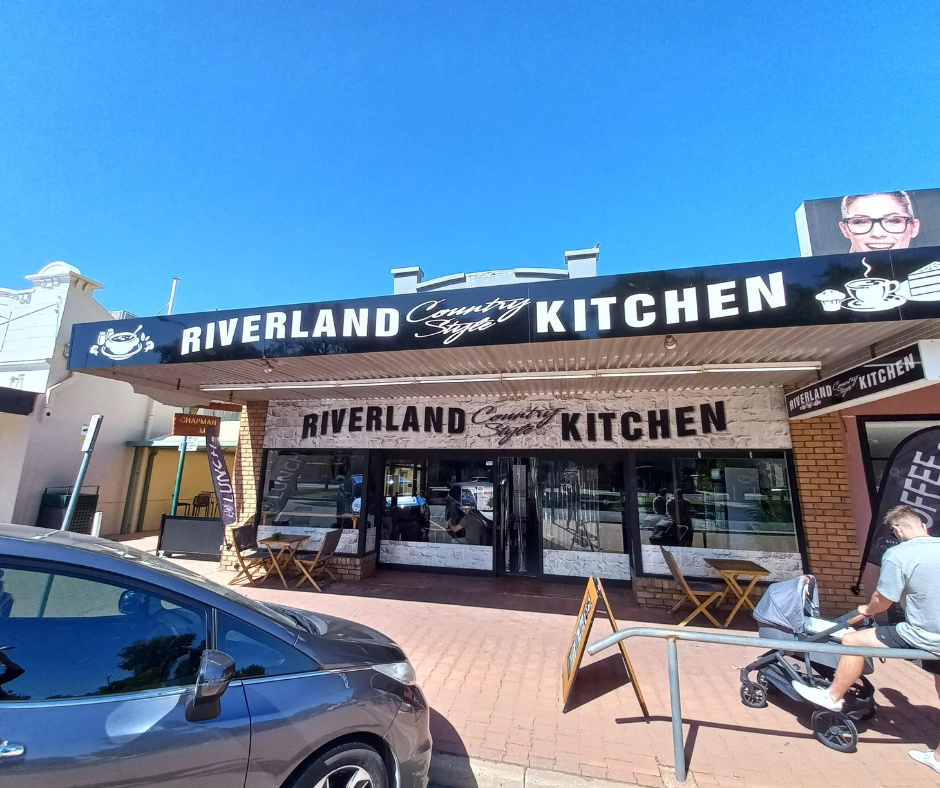 A car is parked in front of the riverland kitchen.