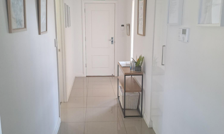 A hallway with white walls and a white door.