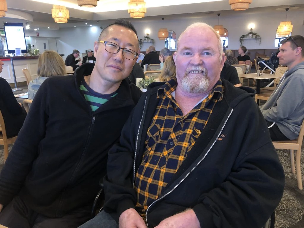 Two men posing for a photo in a restaurant.