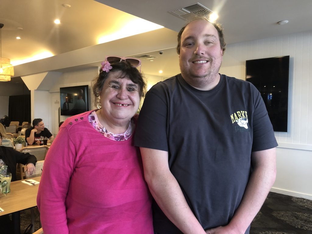 A man and woman standing next to each other in a restaurant.