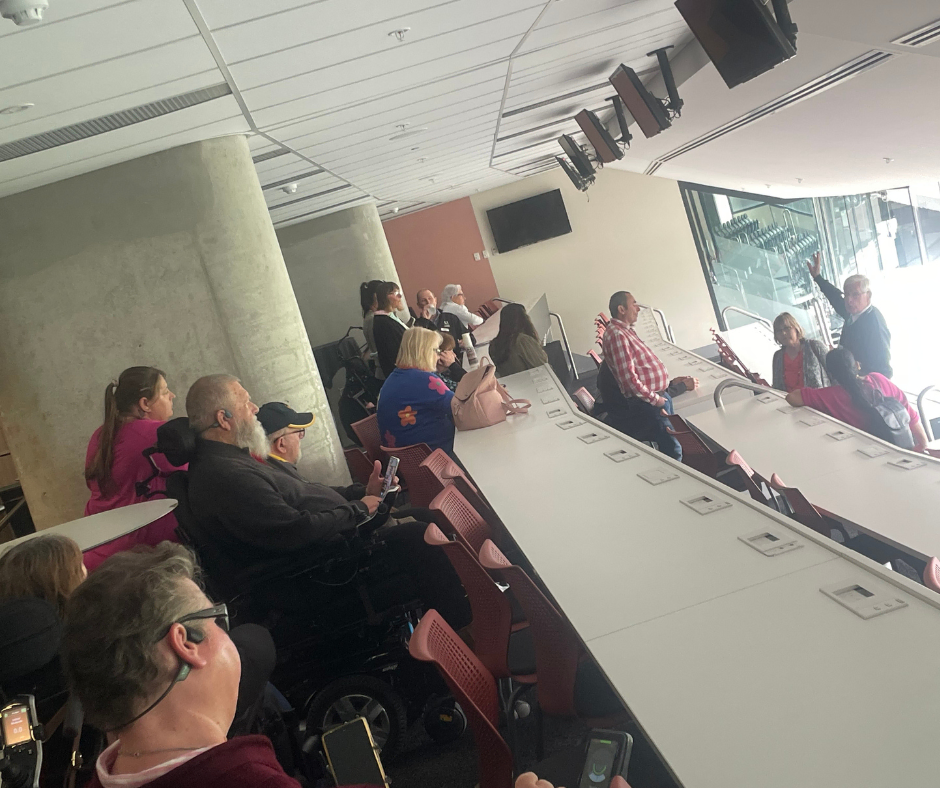 A group of people sitting at a table watching a hockey game.