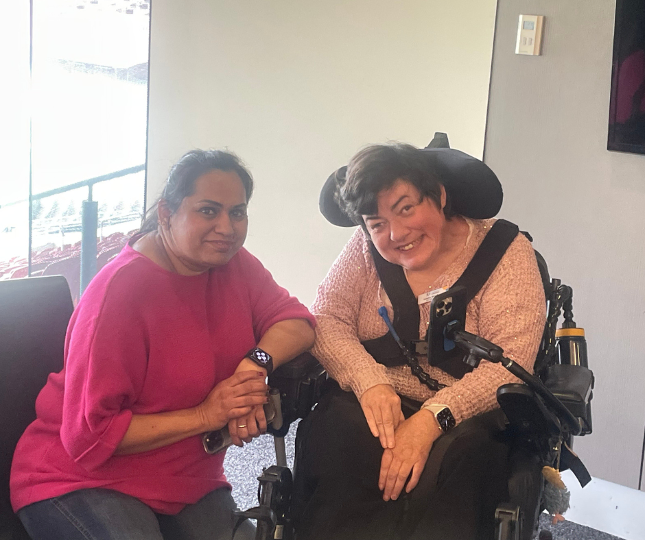 Two women in wheelchairs posing for a photo.