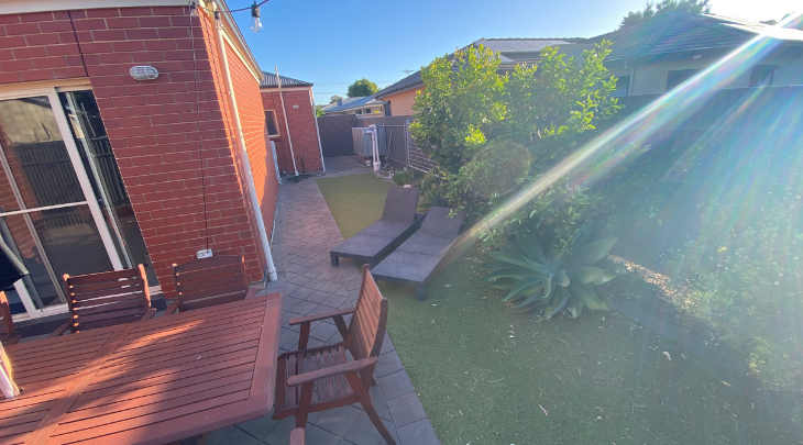 An aerial view of a suburban backyard with a table and chairs.