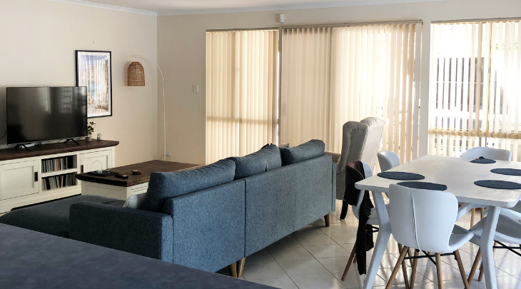 A living room with a tv and a dining table.