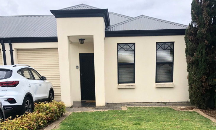 A house with a car parked in front of it.