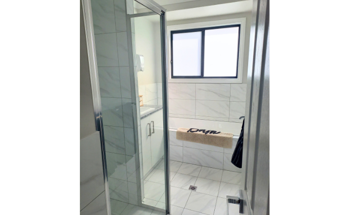 A bathroom with a glass shower door and a toilet - SIL vacancy in Loxton