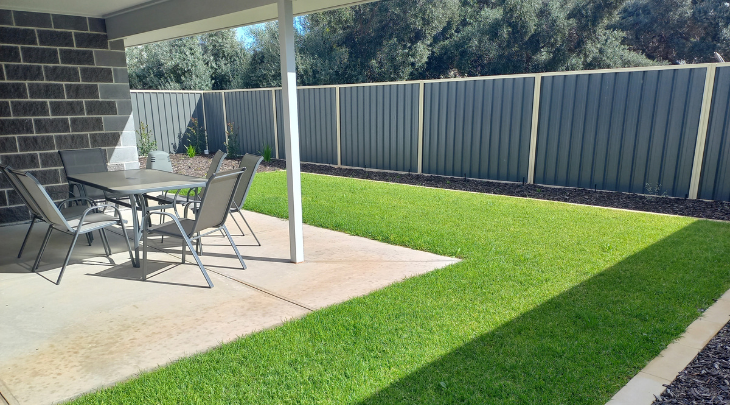 A small backyard with a table and chairs.