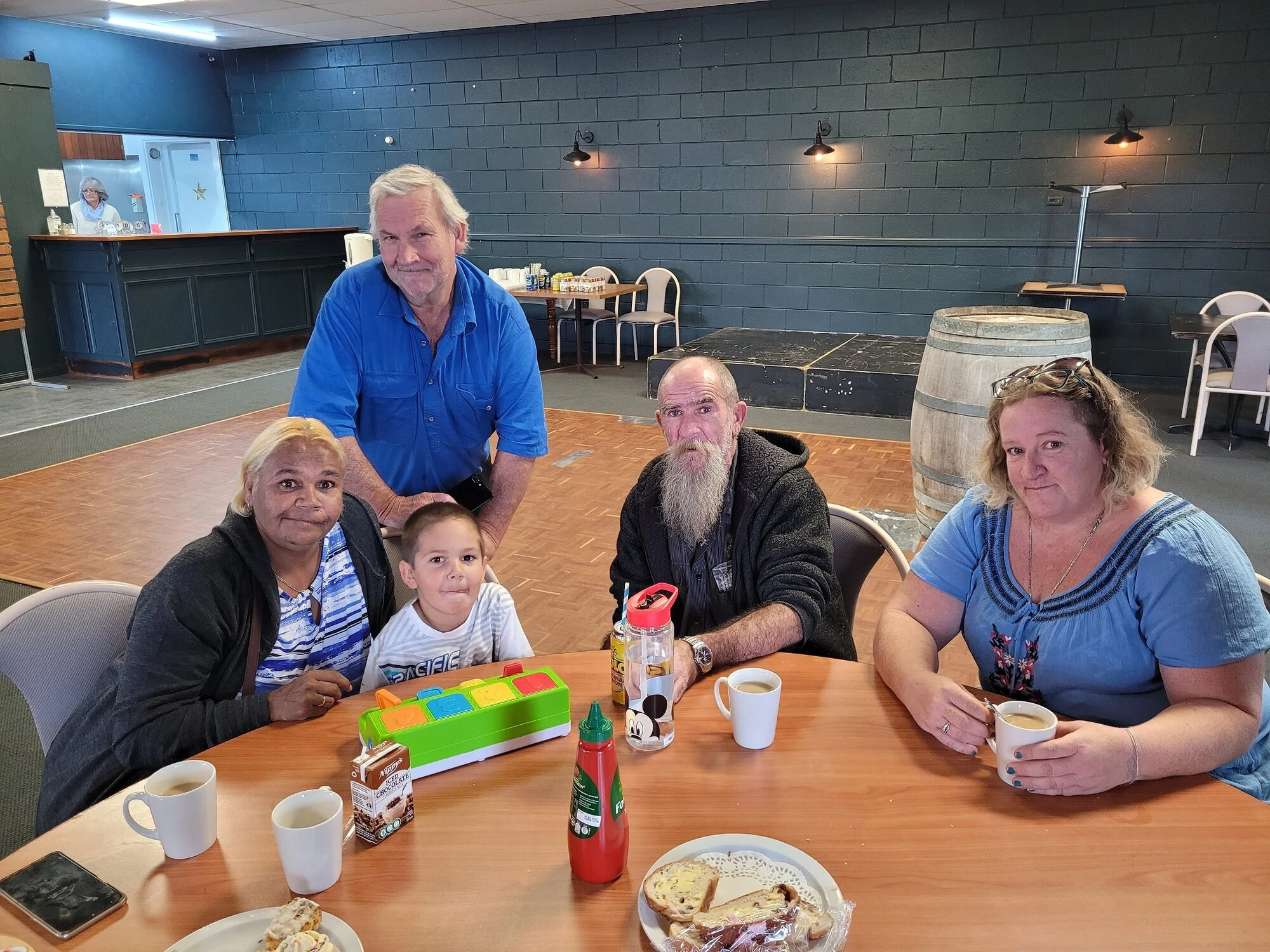 NDIS participants and their disability support workers enjoying hot drinks and nibbles whilst talking