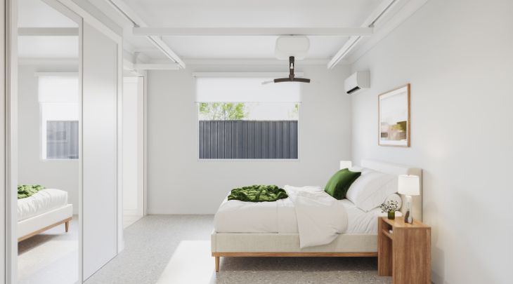 A white bedroom with a green plant on the bed.