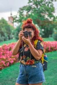 A woman taking a picture with her camera in a park.