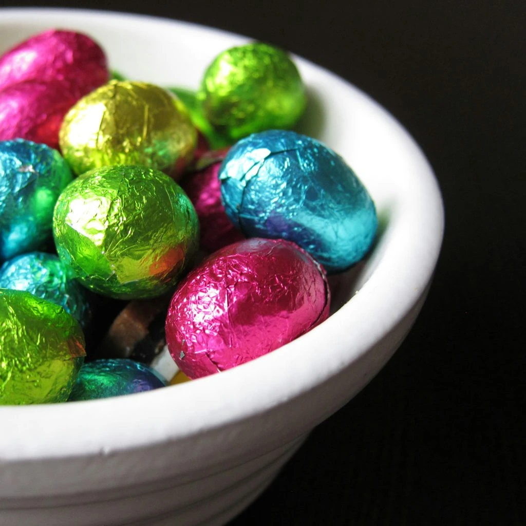 A bowl filled with colorful foil-wrapped chocolate eggs.