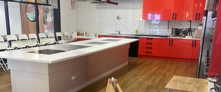 A commercial kitchen with red cabinets and white counter tops -member-only event
