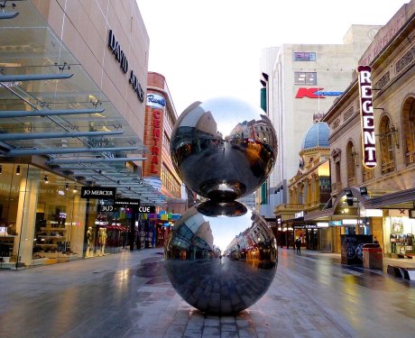 A metal sculpture in the middle of a city street.