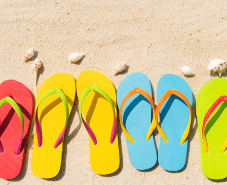 Colorful flip flops in the sand.