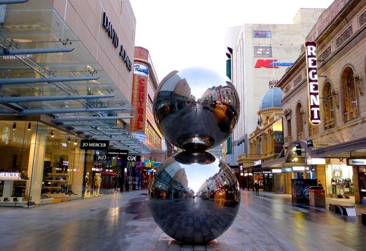 A metal sculpture in the middle of a city street.