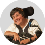 A smiling woman in a wheelchair.