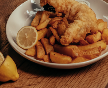 Fish and chips served on a wooden table.
