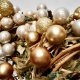 Golden and pearl-colored ornaments clustered with dried leaves and twigs.