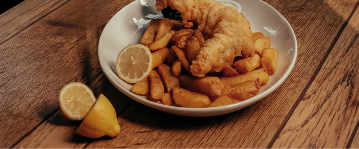 Fish and chips served on a wooden table.