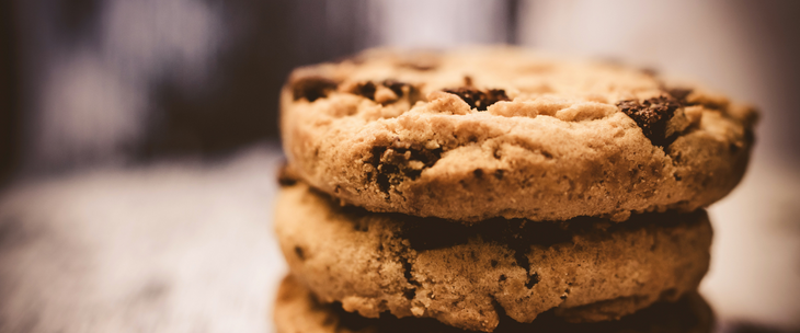 A tempting stack of chocolate chip cookies on a table for a delightful lunchtime treat.