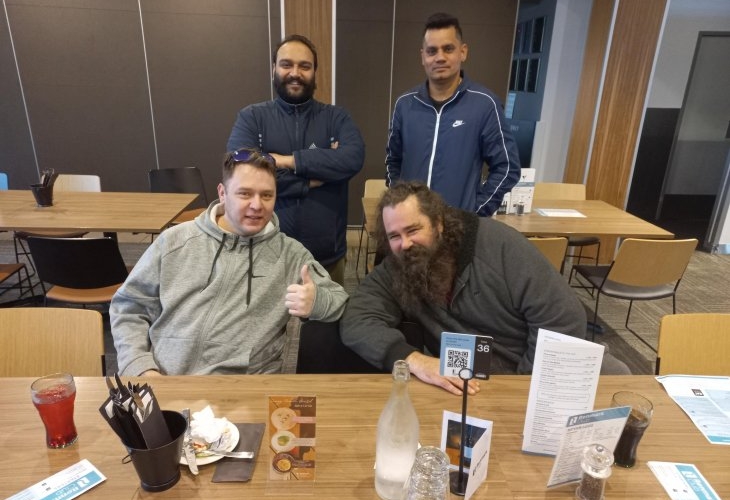 Four men posing for a picture at a table.