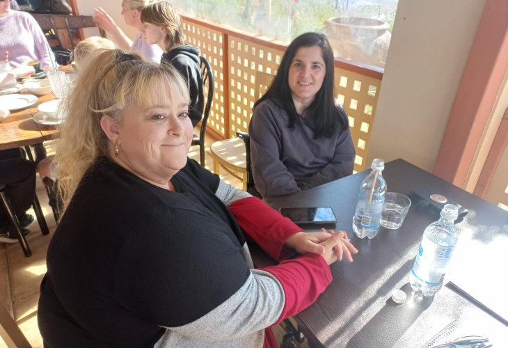 Two women sitting at a table in a restaurant.