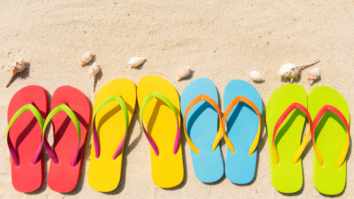 Colorful flip flops in the sand.