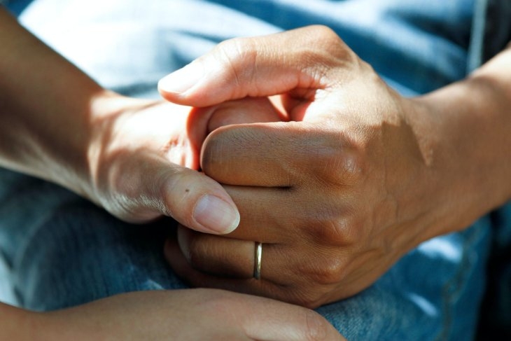 carer holdings hands with a loved one
