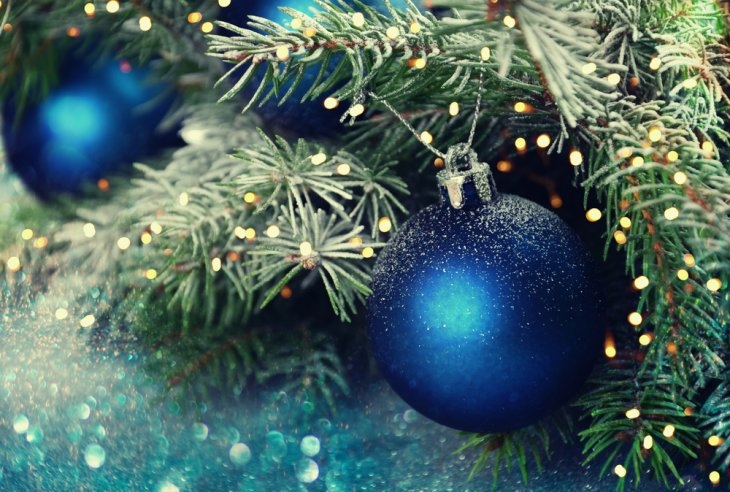 Blue christmas ornaments on a christmas tree.