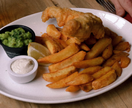 A plate of fish and chips presented on a rustic wooden table.